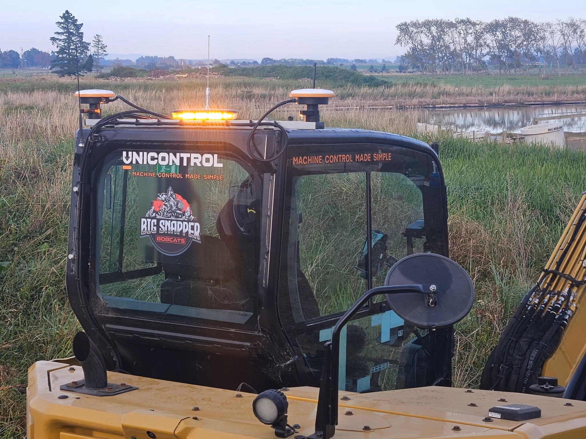 Big Snapper Bobcats logo on an excavator cab at dawn