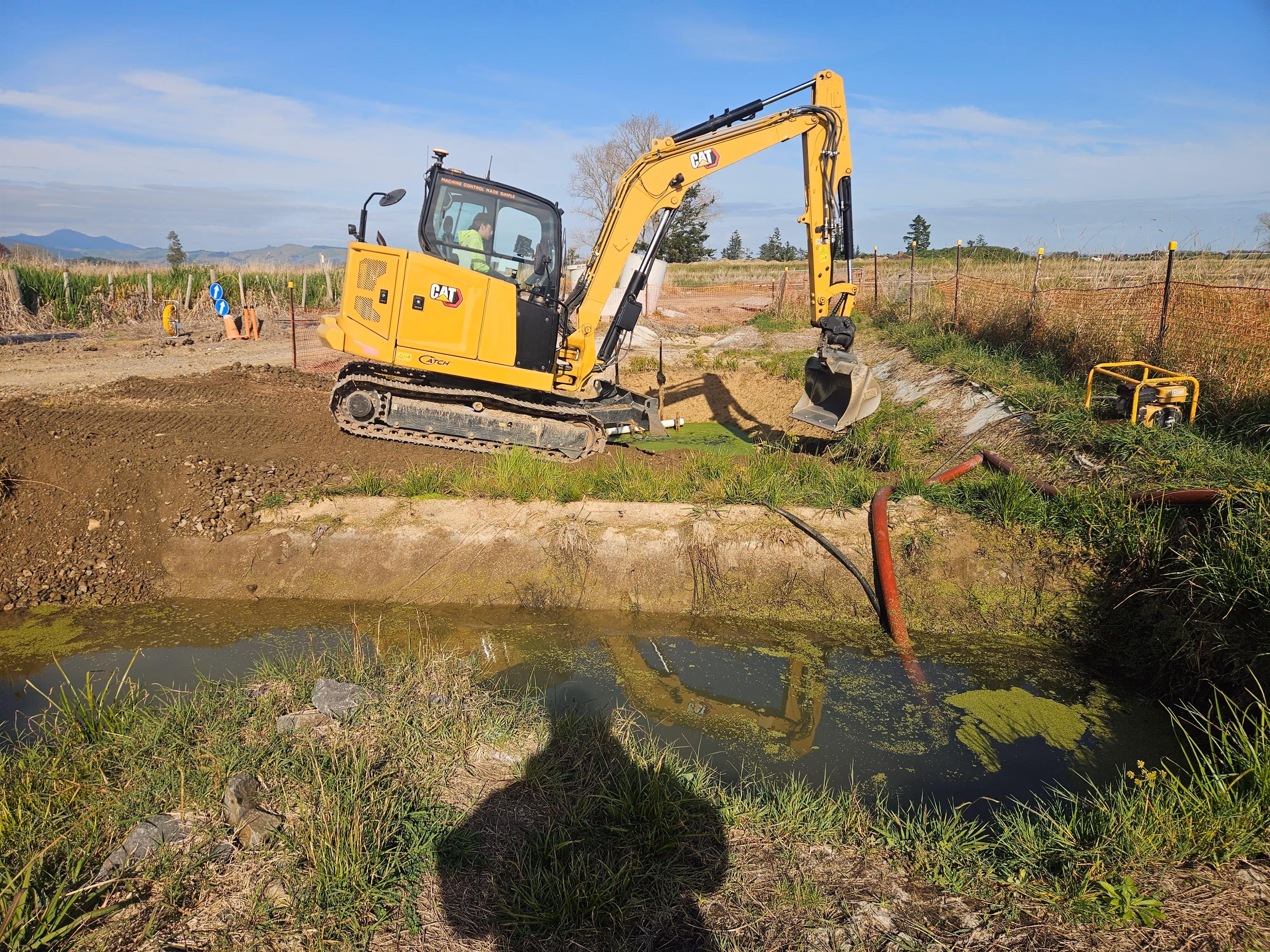 Excavator cutting farm drainage