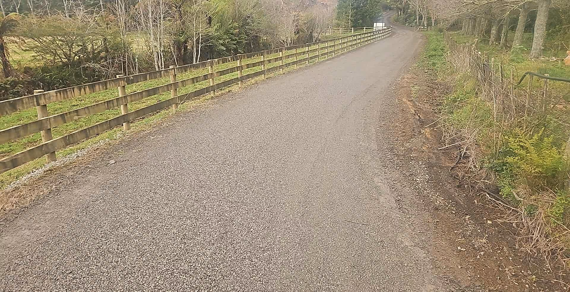 Finished metal driveway running between fenced paddocks