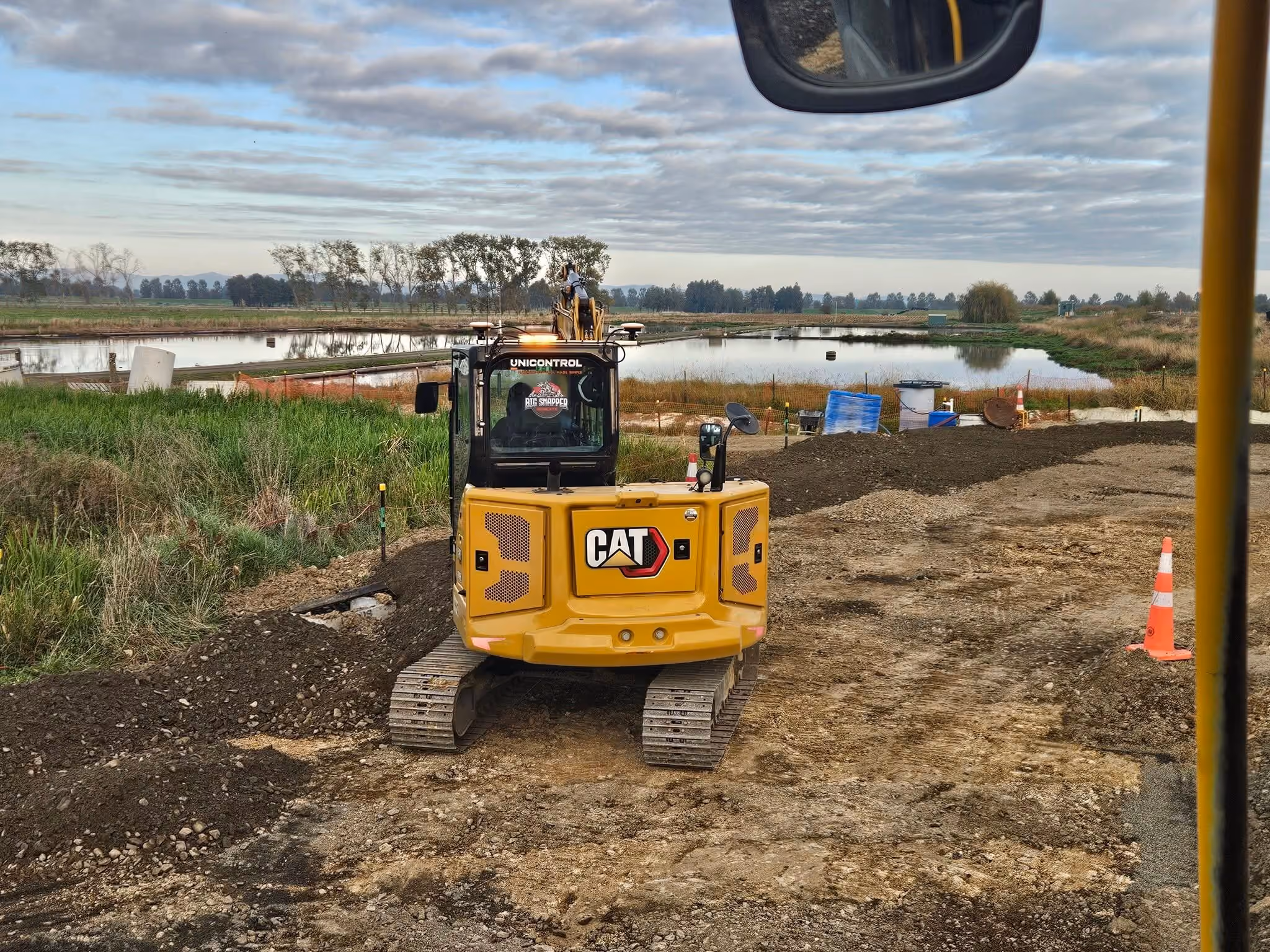 Big Snapper Bobcats Cat excavator working beside a pond