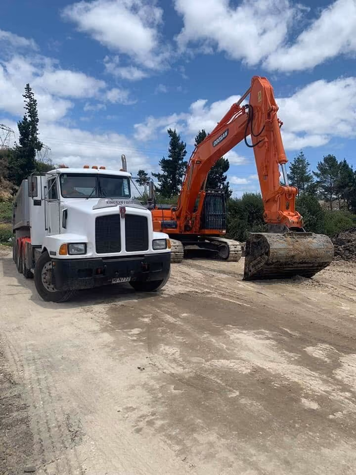 Truck and excavator loading on site
